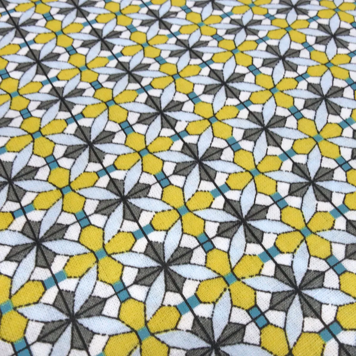 Fabric: cotton poplin with a graphic ornamental pattern flowers in curry yellow, blue, gray, white, and teal; suitable for dresses, children’s clothing, decorative items, and blouses